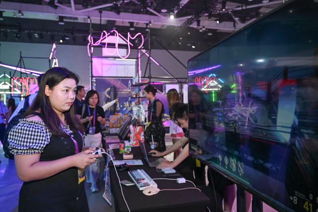 (250704) -- CHONGQING, July 4, 2025 (Xinhua) -- A guest tries a domestic game at the Yongchuan International Convention and Exhibition Center in southwest China's Chongqing, July 4, 2025. The 2025 SCO (the Shanghai Cooperation Organization) Film Festival takes place from July 3 to 7 here, attracting filmmakers from Russia, Belarus, Pakistan and other SCO member states to present their country's films. The event also gathered over 40 domestic film enterprises to present the latest advancements in film technology and production. 
Highlighting the latest advancements in film technology and production across member states, the event features 11 major activities, including film screenings, cooperation forums, a film technology exhibition, and a gala concert. (Xinhua/Chen Cheng)