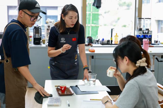(250704) -- GUIYANG, July 4, 2025 (Xinhua) -- Shop assistants talk with coffee lovers at a coffee shop in Guiyang, southwest China's Guizhou Province, June 5, 2025.
  Guiyang has made a name for itself as a coffee powerhouse despite having no coffee farms. Home to more than 3,000 coffee shops, the provincial capital has produced over 10 world and national champions in coffee roasting. Thanks to its vibrant coffee culture, Guiyang is not only drawing a surge of coffee lovers but also boosting youth employment and energizing the local economy. (Xinhua/Liu Xu)