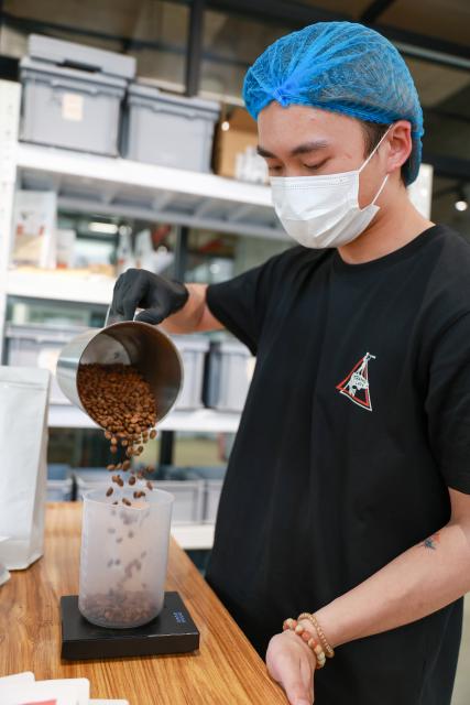 (250704) -- GUIYANG, July 4, 2025 (Xinhua) -- A shop assistant weighs coffee beans at a coffee shop in Guiyang, southwest China's Guizhou Province, June 9, 2025.
  Guiyang has made a name for itself as a coffee powerhouse despite having no coffee farms. Home to more than 3,000 coffee shops, the provincial capital has produced over 10 world and national champions in coffee roasting. Thanks to its vibrant coffee culture, Guiyang is not only drawing a surge of coffee lovers but also boosting youth employment and energizing the local economy. (Xinhua/Liu Xu)