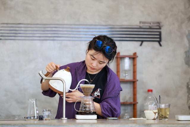 (250704) -- GUIYANG, July 4, 2025 (Xinhua) -- A shop assistant makes coffee at a coffee shop in Guiyang, southwest China's Guizhou Province, June 9, 2025.
  Guiyang has made a name for itself as a coffee powerhouse despite having no coffee farms. Home to more than 3,000 coffee shops, the provincial capital has produced over 10 world and national champions in coffee roasting. Thanks to its vibrant coffee culture, Guiyang is not only drawing a surge of coffee lovers but also boosting youth employment and energizing the local economy. (Xinhua/Liu Xu)