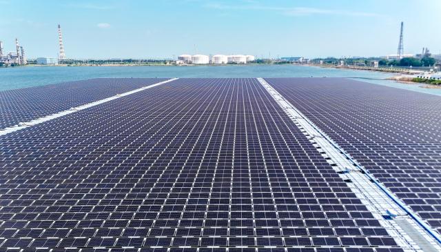(250704) -- QINGDAO, July 4, 2025 (Xinhua) -- An aerial drone photo taken on July 4, 2025 shows a floating offshore photovoltaic (PV) project of Sinopec Qingdao Refining & Chemical Co., Ltd. in a full-seawater environment in Qingdao, east China's Shandong Province. The project was connected to the grid for electricity generation recently. Located in the Xihai'an (West Coast) New Area of the east China's coastal city, the project innovatively adopts a floating structure, with the photovoltaic panels rising and falling close to the water surface with the tide, and uses seawater to efficiently dissipate heat to improve power generation efficiency. With an installed capacity of 7.5 megawatts, it is expected to generate nearly 10 million kilowatt-hours of green electricity annually and reduce carbon dioxide emissions by 8,300 tons. Since it was put into use on July 1, the project has generated a total of 123,100 kilowatt-hours of electricity. (Photo by Zhang Jingang/Xinhua)