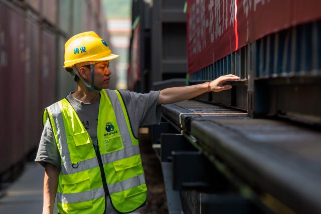 (250704) -- KUNMING, July 4, 2025 (Xinhua) -- A staff member conducts inspection of the first train of the "Zheng He" Sea-Road-Rail International Multimodal Transport Service at Tengjun International Land Port in Kunming, capital of southwest China's Yunnan Province, July 4, 2025. The train left Kunming on Friday. After arriving in Vientiane of Laos via the China-Laos Railway, the goods will be transported to Thailand, Singapore and Bangladesh through other three routes. (Xinhua/Peng Yikai)