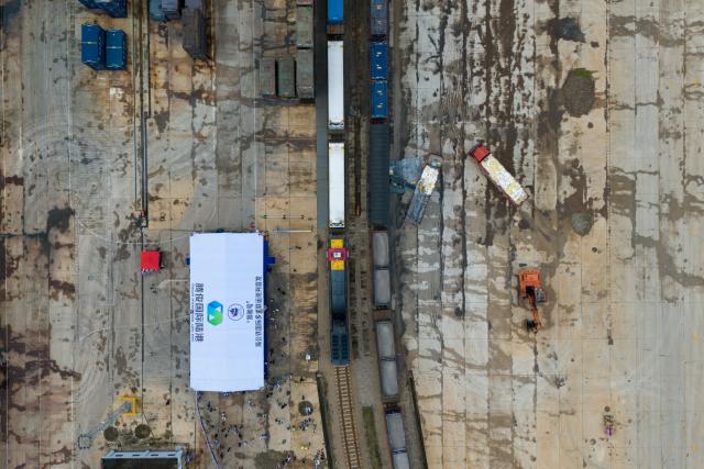 (250704) -- KUNMING, July 4, 2025 (Xinhua) -- An aerial drone photo shows the first train of the "Zheng He" Sea-Road-Rail International Multimodal Transport Service waiting for departure at Tengjun International Land Port in Kunming, capital of southwest China's Yunnan Province, July 4, 2025. The train left Kunming on Friday. After arriving in Vientiane of Laos via the China-Laos Railway, the goods will be transported to Thailand, Singapore and Bangladesh through other three routes. (Xinhua/Peng Yikai)