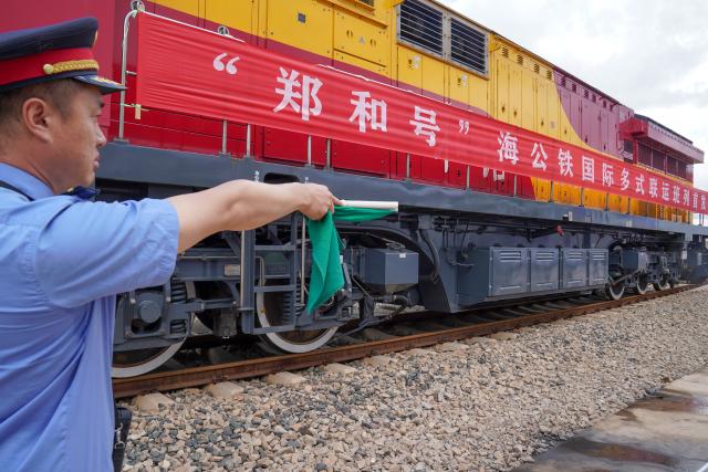 (250704) -- KUNMING, July 4, 2025 (Xinhua) -- A staff member confirms departure signal for the first train of the "Zheng He" Sea-Road-Rail International Multimodal Transport Service at Tengjun International Land Port in Kunming, capital of southwest China's Yunnan Province, July 4, 2025. The train left Kunming on Friday. After arriving in Vientiane of Laos via the China-Laos Railway, the goods will be transported to Thailand, Singapore and Bangladesh through other three routes. (Xinhua/Peng Yikai)
