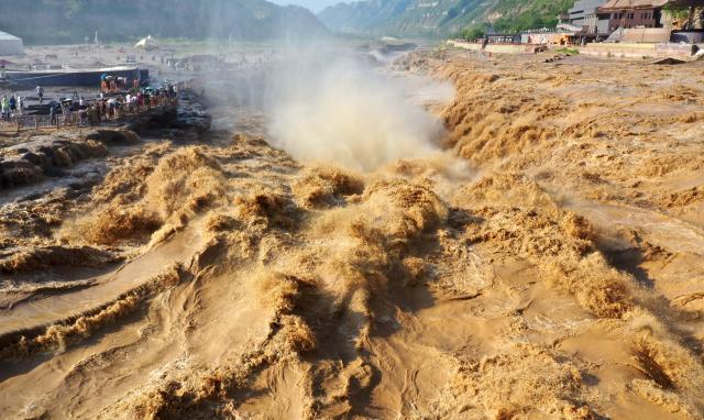 (250704) -- JIXIAN, July 4, 2025 (Xinhua) -- A drone photo shows tourists enjoying the scenery of the Hukou Waterfall on the Yellow River at a scenic area in Jixian County, north China's Shanxi Province, July 4, 2025. (Photo by Lyu Guiming/Xinhua)