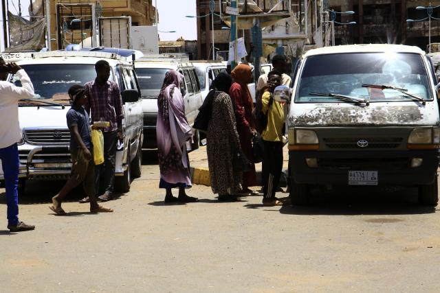 (250704) -- OMDURMAN (SUDAN), July 4, 2025 (Xinhua) -- People wait to get on a vehicle in Omdurman city, north of Khartoum, Sudan, on July 3, 2025. After more than two years of devastating conflict, Sudan's capital Khartoum is slowly emerging from the ruins of war, inching toward a return to normal life. (Photo by Mohamed Khidir/Xinhua) TO GO WITH Feature: Sudan's Khartoum strives to recover amid ongoing civil war