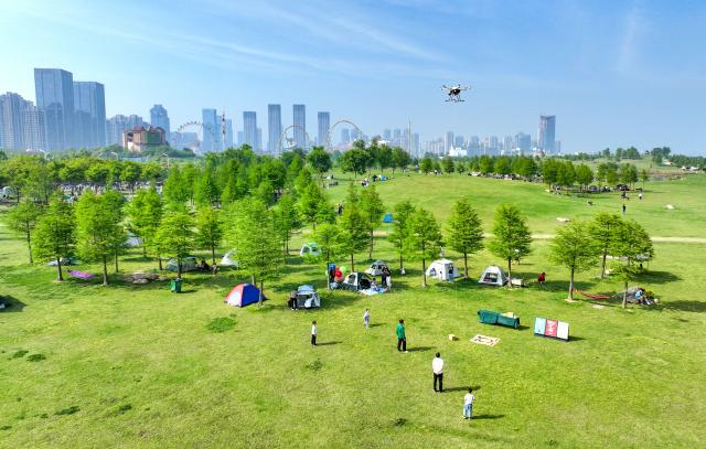 (250705) -- HEFEI, July 5, 2025 (Xinhua) -- An aerial drone photo taken on April 29, 2024 shows a drone delivering a takeout in Hefei, east China's Anhui Province. In recent years, Anhui Province has accelerated the layout of its aerospace information industry, which encompasses low-altitude economy, commercial space, satellite applications, and deep space exploration. From booming "low altitude economy" such as drone delivery and low-altitude tourism, to the aggregation of enterprises into a commercial space industry chain, and the accelerating development of deep space exploration, Anhui further enhanced its independent innovation capabilities, and elevated aerospace information industry into a new growth pole for its economic development. (Photo by Ye Yuting/Xinhua)