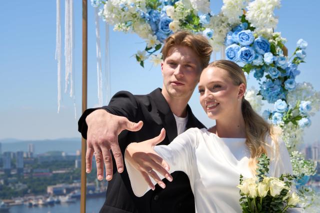 (250705) -- VLADIVOSTOK, July 5, 2025 (Xinhua) -- A couple shows off their wedding rings on a group wedding ceremony at Highland Park in Vladivostok, Russia, July 5, 2025. Three newlywed couples join in a group wedding ceremony here on Thursday, receiving blessings from families and friends. (Photo by Guo Feizhou/Xinhua)