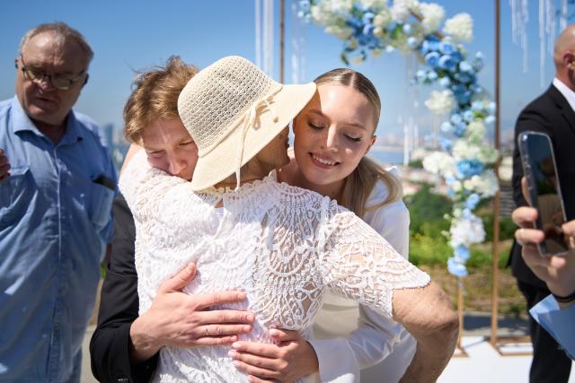 (250705) -- VLADIVOSTOK, July 5, 2025 (Xinhua) -- A couple receives blessings from their relatives and friends on a group wedding ceremony at Highland Park in Vladivostok, Russia, July 5, 2025. Three newlywed couples join in a group wedding ceremony here on Thursday, receiving blessings from families and friends. (Photo by Guo Feizhou/Xinhua)