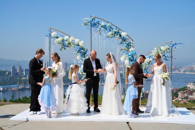 (250705) -- VLADIVOSTOK, July 5, 2025 (Xinhua) -- Three couples exchange rings on a group wedding ceremony at Highland Park in Vladivostok, Russia, July 5, 2025. Three newlywed couples join in a group wedding ceremony here on Thursday, receiving blessings from families and friends. (Photo by Guo Feizhou/Xinhua)