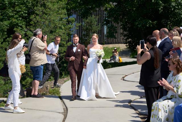 (250705) -- VLADIVOSTOK, July 5, 2025 (Xinhua) -- A couple enters a group wedding ceremony at Highland Park in Vladivostok, Russia, July 5, 2025. Three newlywed couples join in a group wedding ceremony here on Thursday, receiving blessings from families and friends. (Photo by Guo Feizhou/Xinhua)