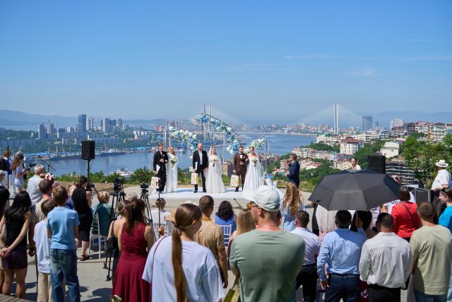 (250705) -- VLADIVOSTOK, July 5, 2025 (Xinhua) -- Three couples join in a group wedding ceremony at Highland Park in Vladivostok, Russia, July 5, 2025. Three newlywed couples join in a group wedding ceremony here on Thursday, receiving blessings from families and friends. (Photo by Guo Feizhou/Xinhua)