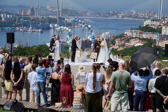 (250705) -- VLADIVOSTOK, July 5, 2025 (Xinhua) -- Three couples join in a group wedding ceremony at Highland Park in Vladivostok, Russia, July 5, 2025. Three newlywed couples join in a group wedding ceremony here on Thursday, receiving blessings from families and friends. (Photo by Guo Feizhou/Xinhua)