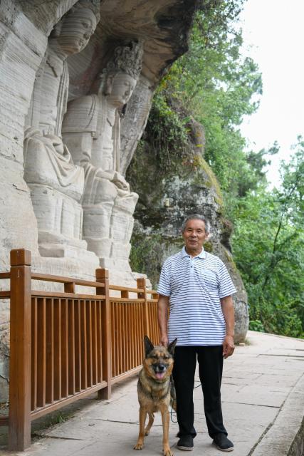 (250705) -- ZIYANG, July 5, 2025 (Xinhua) -- Zeng Xiangyu inspects stone carvings with his dog at Mingshan Temple in Shiyang Town of Ziyang City, southwest China's Sichuan Province, June 14, 2025. On top of Hutou Mountain in Shiyang Town of Ziyang City, a 76-year-old man named Zeng Xiangyu is a familiar sight to locals. Accompanied by his dog, he patrols the circular path around Mingshan Temple, meticulously inspecting each stone carving.
   Dating back to the Tang Dynasty (618-907), Mingshan Temple houses over 60 statues inside 13 caves. Most of these magnificent works of artistry were chiseled during the Song Dynasty (960-1127).
   In the 1980s, Zeng first came to the mountain with his uncle for temple renovation work. Since then, he has devoted his life to safeguarding these relics. When Mingshan Temple was listed as a national key cultural relics protection site in 2006, Zeng formally became its on-site cultural heritage administrator.
   Today, as visitors flock to Mingshan Temple, Zeng occasionally steps into a part-time role as a guide, narrating centuries-old tales. He has expressed that he wishes to protect these sculptural treasures passed down from ancestors to future generations. (Xinhua/Xu Bingjie)