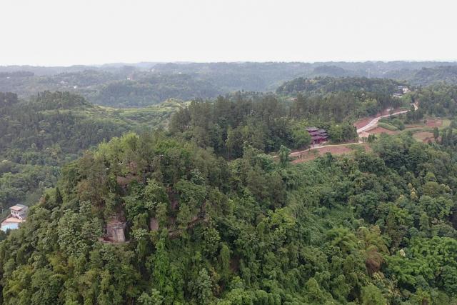 (250705) -- ZIYANG, July 5, 2025 (Xinhua) -- An aerial drone photo shows a view of Mingshan Temple (front) atop Hutou Mountain in Shiyang Town of Ziyang City, southwest China's Sichuan Province, June 14, 2025. On top of Hutou Mountain in Shiyang Town of Ziyang City, a 76-year-old man named Zeng Xiangyu is a familiar sight to locals. Accompanied by his dog, he patrols the circular path around Mingshan Temple, meticulously inspecting each stone carving.
   Dating back to the Tang Dynasty (618-907), Mingshan Temple houses over 60 statues inside 13 caves. Most of these magnificent works of artistry were chiseled during the Song Dynasty (960-1127).
   In the 1980s, Zeng first came to the mountain with his uncle for temple renovation work. Since then, he has devoted his life to safeguarding these relics. When Mingshan Temple was listed as a national key cultural relics protection site in 2006, Zeng formally became its on-site cultural heritage administrator.
   Today, as visitors flock to Mingshan Temple, Zeng occasionally steps into a part-time role as a guide, narrating centuries-old tales. He has expressed that he wishes to protect these sculptural treasures passed down from ancestors to future generations. (Xinhua/Xu Bingjie)