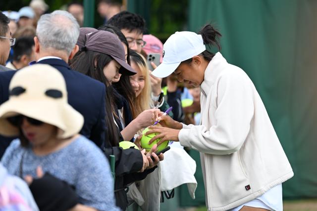 (250705) -- LONDON, July 5, 2025 (Xinhua) -- Zhang Shuai (1st R) signs an autograph for fans after winning the mixed doubles first round match between Zhang Shuai of China/Marcelo Arevalo of El Salvador and Chan Hao-Ching of Chinese Taipei/Andre Goransson of Sweden at the Wimbledon Tennis Championships in London, Britain, July 5, 2025. (Xinhua/Zhao Dingzhe)