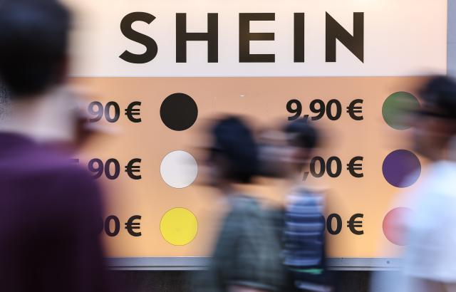 (250706) -- ROME, July 6, 2025 (Xinhua) -- People walk past a poster board in Rome, Italy, July 5, 2025. Italy's summer sales started on Saturday, running between six and eight weeks. (Xinhua/Li Jing)