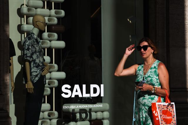 (250706) -- ROME, July 6, 2025 (Xinhua) -- A woman walks past a shop window in Rome, Italy, July 5, 2025. Italy's summer sales started on Saturday, running between six and eight weeks. (Xinhua/Li Jing)