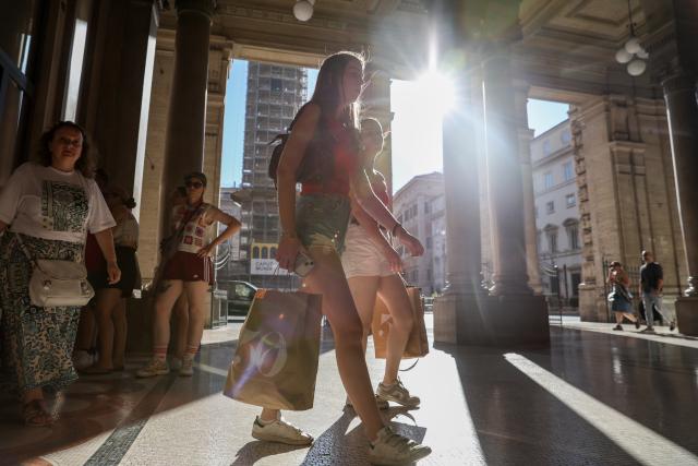 (250706) -- ROME, July 6, 2025 (Xinhua) -- People walk with shopping bags in Rome, Italy, July 5, 2025. Italy's summer sales started on Saturday, running between six and eight weeks. (Xinhua/Li Jing)