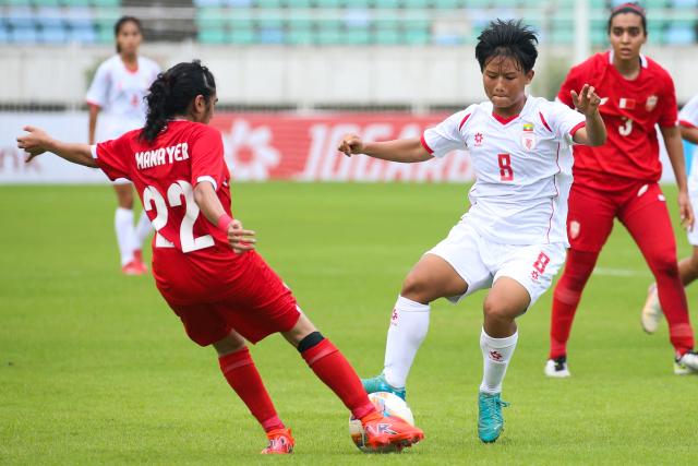 (250706) -- YANGON, July 6, 2025 (Xinhua) -- San Thaw Thaw (2nd R) of Myanmar vies with Manayer Ahmed Thani of Bahrain during the AFC Women's Asian Cup 2026 qualifiers Group C football match between Myanmar and Bahrain in Yangon, Myanmar, July 5, 2025. (Xinhua/Myo Kyaw Soe)