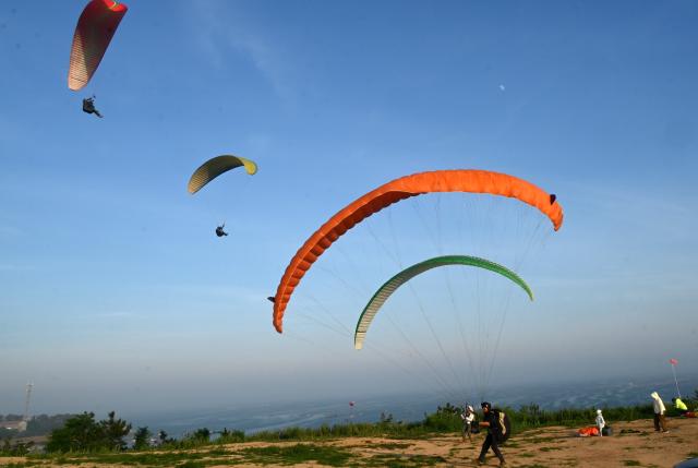 (250706) -- BEIJING, July 6, 2025 (Xinhua) -- Tourists enjoy paragliding in Rongcheng City, east China's Shandong Province, July 5, 2025.
  With the arrival of summer vacation, many places in China have entered the peak tourist season. (Photo by Yang Zhili/Xinhua)