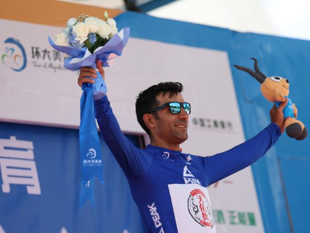 (250706) -- XINING, July 6, 2025 (Xinhua) -- Hasan Seyfollahifard of Tianyoude Hotel Cycling Team celebrates in the blue jersey on the podium after Stage 1 of the Tour of Magnificent Qinghai international road cycling race in Xining, northwest China's Qinghai Province, July 6, 2025. (Xinhua/Zhang Long)