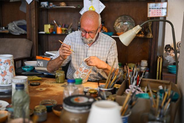 (250706) -- IZNIK, July 6, 2025 (Xinhua) -- Turkish ceramic artist Adil Can Guven works in his studio in Iznik, Türkiye on June 26, 2025. Walking through the streets of Iznik, Türkiye, one finds ceramic elements everywhere. The clock tower in the city center is adorned with tile murals depicting sailing ships. House numbers on ordinary homes are carefully inscribed on elegant ceramic tiles. Family-run porcelain workshops and ceramic stalls line the streets.
  Iznik is known as Türkiye's "porcelain capital." From the 15th to the 17th century, the city flourished as a center for producing blue-and-white porcelain but gradually declined in the following centuries.
  In recent years, however, Iznik has been committed to reviving its ceramic heritage and rejuvenating its reputation as Türkiye's "porcelain capital." As part of this effort, Iznik has strengthened exchanges with Jingdezhen, often dubbed China's "porcelain capital."
  In 2021, the two porcelain capitals became sister cities, and the Iznik municipal government organized multiple visits to Jingdezhen for study and exchange.
   In 2025, Jingdezhen's second official overseas flagship store opened in Türkiye, and the two cities also signed a ceramic industry alliance cooperation agreement. Today, Iznik and Jingdezhen are deepening their ties through ceramics, adding a new layer to the modern story of the Silk Road. (Xinhua/Liu Lei)