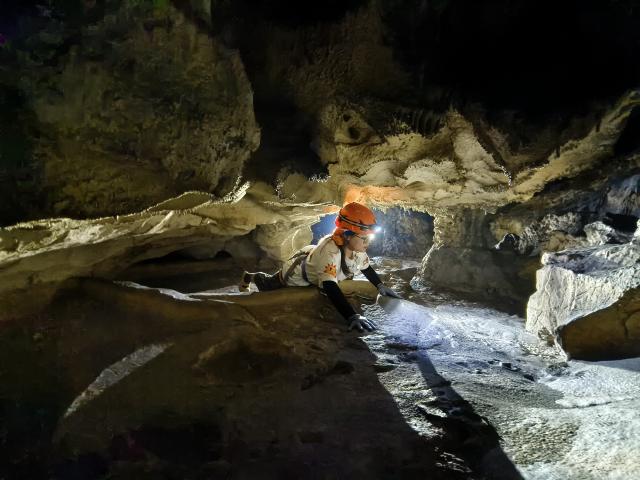 (250706) -- BEIJING, July 6, 2025 (Xinhua) -- A visitor explores a cave at the Forest Coolpark scenic area in Libo County, southwest China's Guizhou Province, April 25, 2025. (The Forest Coolpark scenic area/Handout via Xinhua)