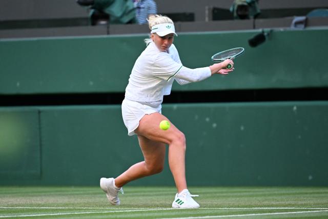 (250708) -- LONDON, July 8, 2025 (Xinhua) -- Clara Tauson hits a return during the women's singles round of 8 match between Iga Swiatek of Poland and Clara Tauson of Denmark at the Wimbledon Tennis Championships in London, Britain, July 7, 2025. (Xinhua/Zhao Dingzhe)