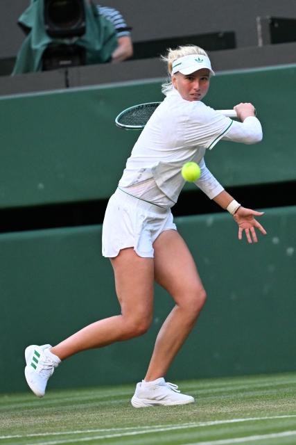 (250708) -- LONDON, July 8, 2025 (Xinhua) -- Clara Tauson hits a return during the women's singles round of 8 match between Iga Swiatek of Poland and Clara Tauson of Denmark at the Wimbledon Tennis Championships in London, Britain, July 7, 2025. (Xinhua/Zhao Dingzhe)