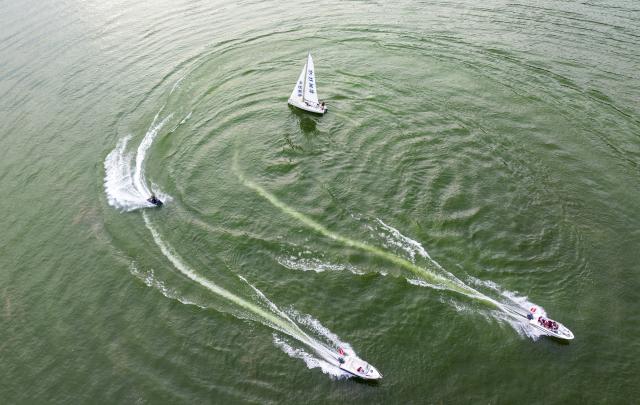 (250708) -- ENSHI, July 8, 2025 (Xinhua) -- An aerial drone photo taken on July 7, 2025 shows tourists experiencing water sports activities at an aquatic sports center in Jianshi County, Enshi Tujia and Miao Autonomous Prefecture, central China's Hubei Province. Enshi is a well-known summer travel destination in central China. Tapping diverse ecological resources, such as unique karst landforms, pleasant alpine climate, and dense primeval forests, the local authorities have actively developed summer tourism, and meticulously created diversified tourism products, like exploring canyon and cave, rafting on Qingjiang River and experiencing the culture of Tujia ethnic group. (Photo by Zheng Jiayu/Xinhua)