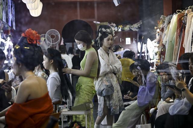 (250708) -- NANCHANG, July 8, 2025 (Xinhua) -- Tourists are seen at a photo studio near the Tengwang Pavilion scenic area in Nanchang City, east China's Jiangxi Province, on July 7, 2025. The Tengwang Pavilion, the 29th iteration in its 1,400-year history, features intricately carved beams and vibrantly painted rafters. It stands majestically along the banks of the Ganjiang River, which winds through eastern China's Jiangxi Province. About 90 percent of the scenic area has been open to the public for free as of Jan. 1 this year when a northward expansion project was fully completed. (Xinhua/Liu Jinhai)