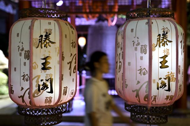 (250708) -- NANCHANG, July 8, 2025 (Xinhua) -- A tourist visits the Tengwang Pavilion scenic area at night in Nanchang City, east China's Jiangxi Province, on July 7, 2025. The Tengwang Pavilion, the 29th iteration in its 1,400-year history, features intricately carved beams and vibrantly painted rafters. It stands majestically along the banks of the Ganjiang River, which winds through eastern China's Jiangxi Province. About 90 percent of the scenic area has been open to the public for free as of Jan. 1 this year when a northward expansion project was fully completed. (Xinhua/Liu Jinhai)