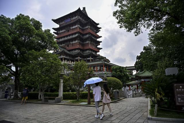 (250708) -- NANCHANG, July 8, 2025 (Xinhua) -- Tourists visit the Tengwang Pavilion scenic area in Nanchang City, east China's Jiangxi Province, on July 7, 2025. The Tengwang Pavilion, the 29th iteration in its 1,400-year history, features intricately carved beams and vibrantly painted rafters. It stands majestically along the banks of the Ganjiang River, which winds through eastern China's Jiangxi Province. About 90 percent of the scenic area has been open to the public for free as of Jan. 1 this year when a northward expansion project was fully completed. (Xinhua/Liu Jinhai)