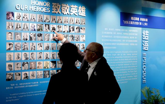 (250708) -- SHANGHAI, July 8, 2025 (Xinhua) -- Visitors discuss with each other while viewing exhibits at the Flying Tigers Photo Exhibition in Shanghai, east China, July 8, 2025. Themed "Remembering heroes and creating the future together," the exhibition opened here on Tuesday, showcasing hundreds of valuable photos as well as other items of historic significance contributed by veterans of the Flying Tigers. (Xinhua/Fang Zhe)