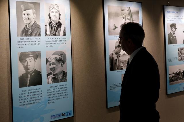 (250708) -- SHANGHAI, July 8, 2025 (Xinhua) -- A visitor views exhibits at the Flying Tigers Photo Exhibition in Shanghai, east China, July 8, 2025. Themed "Remembering heroes and creating the future together," the exhibition opened here on Tuesday, showcasing hundreds of valuable photos as well as other items of historic significance contributed by veterans of the Flying Tigers. (Xinhua/Fang Zhe)
