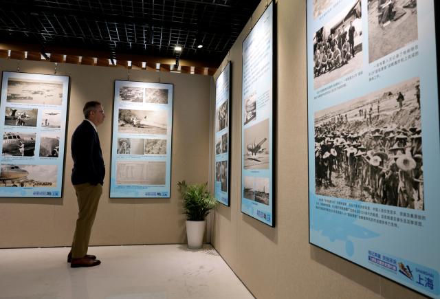 (250708) -- SHANGHAI, July 8, 2025 (Xinhua) -- A visitor views exhibits at the Flying Tigers Photo Exhibition in Shanghai, east China, July 8, 2025. Themed "Remembering heroes and creating the future together," the exhibition opened here on Tuesday, showcasing hundreds of valuable photos as well as other items of historic significance contributed by veterans of the Flying Tigers. (Xinhua/Fang Zhe)