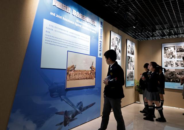 (250708) -- SHANGHAI, July 8, 2025 (Xinhua) -- Children view exhibits at the Flying Tigers Photo Exhibition in Shanghai, east China, July 8, 2025. Themed "Remembering heroes and creating the future together," the exhibition opened here on Tuesday, showcasing hundreds of valuable photos as well as other items of historic significance contributed by veterans of the Flying Tigers. (Xinhua/Fang Zhe)