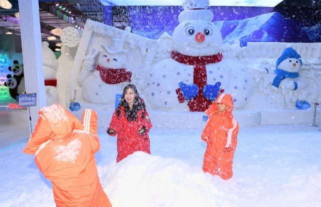 (250709) -- HARBIN, July 9, 2025 (Xinhua) -- Tourists play with artificial snow at the ice and snow art gallery of the Sun Island scenic spot in Harbin, northeast China's Heilongjiang Province, on July 9, 2025. The newly upgraded ice and snow art gallery of the Sun Island scenic spot opened to public recently, enabling visitors to enjoy ice and snow in summer. (Photo by Liu Yang/Xinhua)