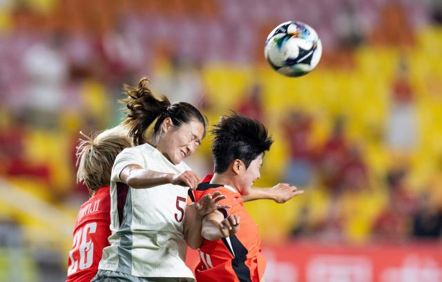 (250709) -- SUWON, July 9, 2025 (Xinhua) -- Wu Haiyan (C) of China jumps up for a header with Kim Minji (L) of South Korea during the women's football match between China and South Korea at the EAFF (East Asian Football Federation) E-1 Football Championship 2025 Final in Suwon, South Korea, July 9, 2025. (Photo by Jun Hyosang/Xinhua)