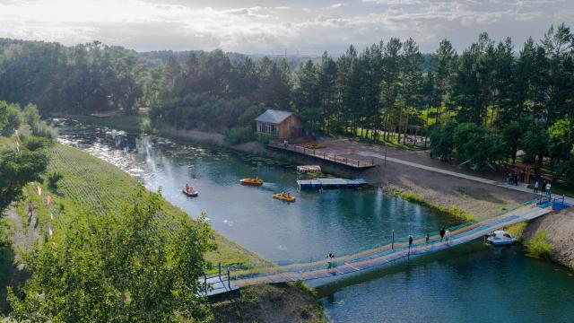 (250711) -- HULUN BUIR, July 11, 2025 (Xinhua) -- An aerial drone photo taken on July 10, 2025 shows tourists enjoying boating at a forest farm in Yakeshi of Hulun Buir, north China's Inner Mongolia Autonomous Region. In recent years, Yakeshi has leveraged its abundant forest resources to integrate forestry development with tourism, promoting "under-forest" economy to attract tourists. (Xinhua/Ma Jinrui)