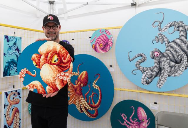 (250712) -- TORONTO, July 12, 2025 (Xinhua) -- An artist poses for photos with his artworks during the 2025 Toronto Outdoor Art Fair in Toronto, Canada, on July 11, 2025. As one of the largest fairs of its kind in Canada, this three-day event kicked off here on Friday with the participation of over 400 artists. (Photo by Zou Zheng/Xinhua)