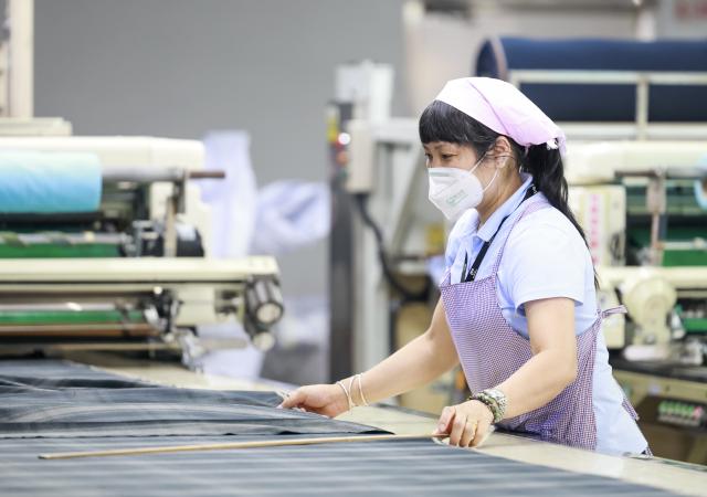 (250712) -- URUMQI, July 12, 2025 (Xinhua) -- An employee works at a factory of Esquel Group in Foshan, south China's Guangdong Province, May 16, 2025. TO GO WITH "Interview: China's textile giant drives green innovation as Xinjiang evolves" (Xinhua/Wang Fei)