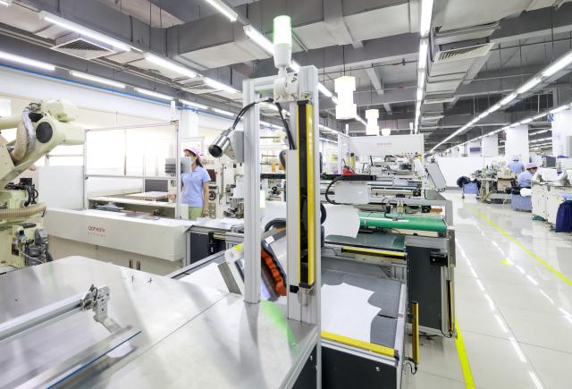 (250712) -- URUMQI, July 12, 2025 (Xinhua) -- Employees work at a factory of Esquel Group in Foshan, south China's Guangdong Province, May 16, 2025. TO GO WITH "Interview: China's textile giant drives green innovation as Xinjiang evolves" (Xinhua/Wang Fei)