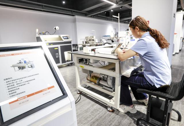 (250712) -- URUMQI, July 12, 2025 (Xinhua) -- An employee adjusts the equipment at a factory of Esquel Group in Foshan, south China's Guangdong Province, May 16, 2025. TO GO WITH "Interview: China's textile giant drives green innovation as Xinjiang evolves" (Xinhua/Wang Fei)