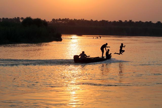(250712) -- BAGHDAD, July 12, 2025 (Xinhua) -- People enjoy swimming in the Tigris River in Baghdad, Iraq at sunset time on July 11, 2025. (Xinhua/Khalil Dawood)