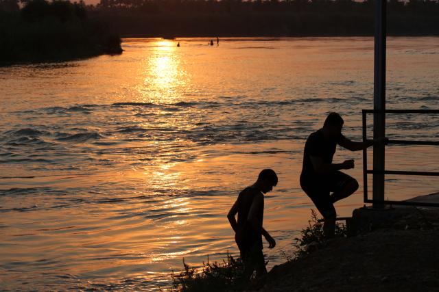 (250712) -- BAGHDAD, July 12, 2025 (Xinhua) -- People have fun on the bank of the Tigris River in Baghdad, Iraq at sunset time on July 11, 2025. (Xinhua/Khalil Dawood)