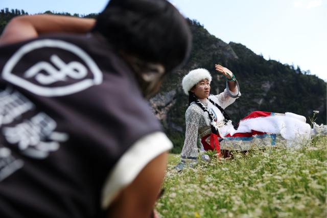(250712) -- TEWO, July 12, 2025 (Xinhua) -- A tourist poses for photos at Zhagana Village in Tewo County of Gannan Tibetan Autonomous Prefecture, northwest China's Gansu Province, July 11, 2025.
  Zhagana village is a renowned destination that attracts throngs of tourists for its varied terrain and unique ethnic customs. 
  The village, with an average altitude of about 3,000 meters, earned a coveted spot on the United Nations World Tourism Organization's (UNWTO) "Best Tourism Villages" list for 2023. (Xinhua/Chen Bin)