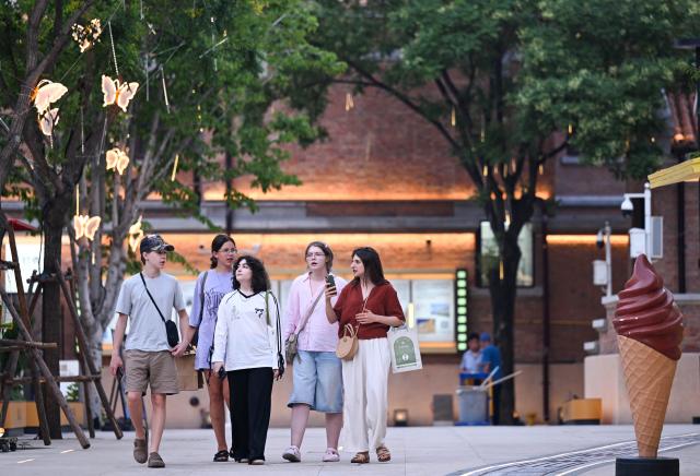 (250712) -- TIANJIN, July 12, 2025 (Xinhua) -- Tourists enjoy leisure time at the Wudadao historical urban area in north China's Tianjin, July 9, 2025. The Minyuan 1920 Block, a recently completed infrastructure enhancement project, has officially opened to the public. The project transforms sections of Hunan Road and Luoyang Avenue into a pedestrian zone and connects Minyuan Square and Wudadao Park, injecting vitality into the century-old historical area. (Xinhua/Zhao Zishuo)