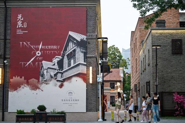 (250712) -- TIANJIN, July 12, 2025 (Xinhua) -- Tourists enjoy leisure time at the Wudadao historical urban area in north China's Tianjin, July 9, 2025. The Minyuan 1920 Block, a recently completed infrastructure enhancement project, has officially opened to the public. The project transforms sections of Hunan Road and Luoyang Avenue into a pedestrian zone and connects Minyuan Square and Wudadao Park, injecting vitality into the century-old historical area. (Xinhua/Zhao Zishuo)